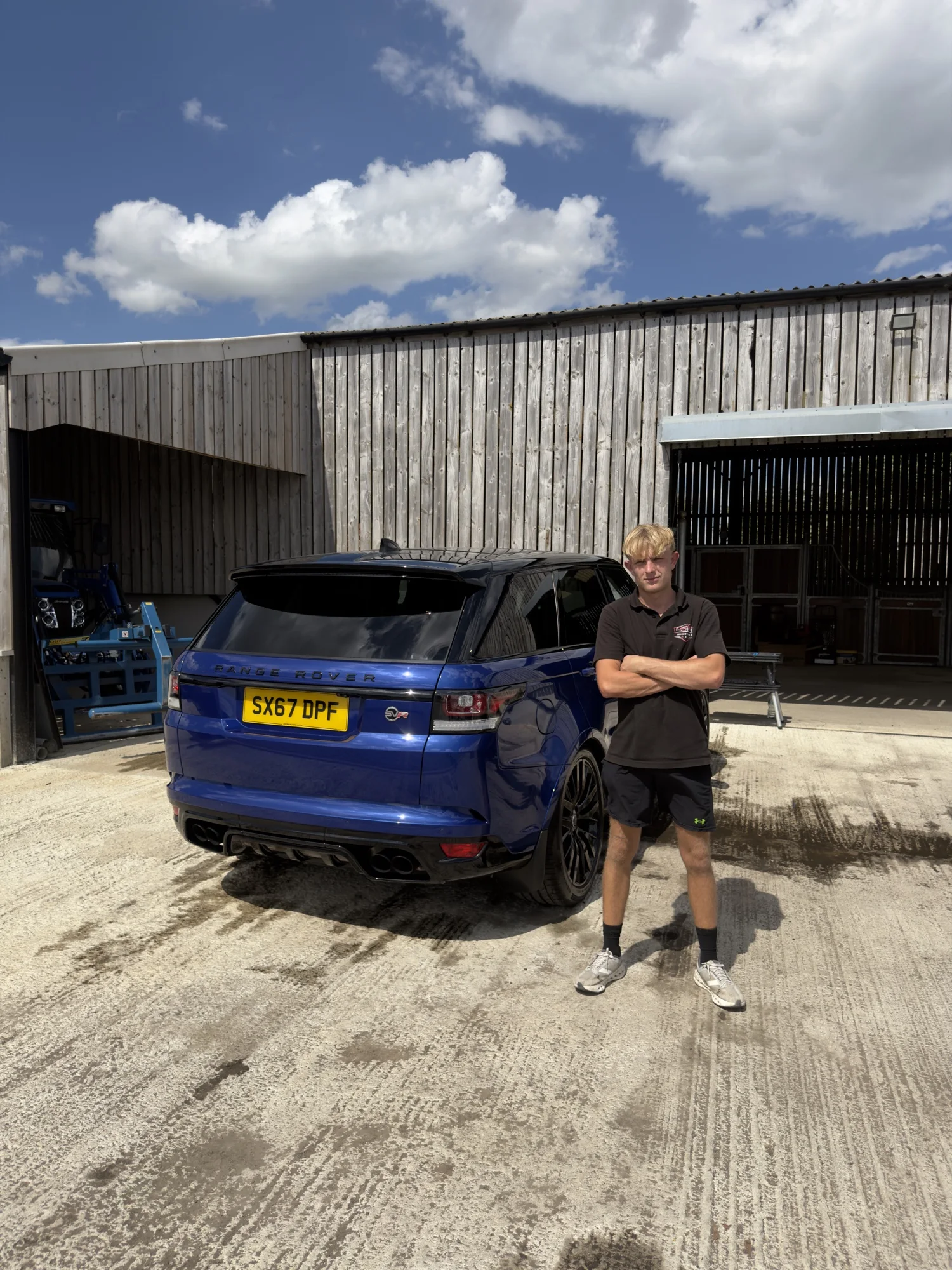 Nathan from NBGDETAILS beside a detailed blue Range Rover